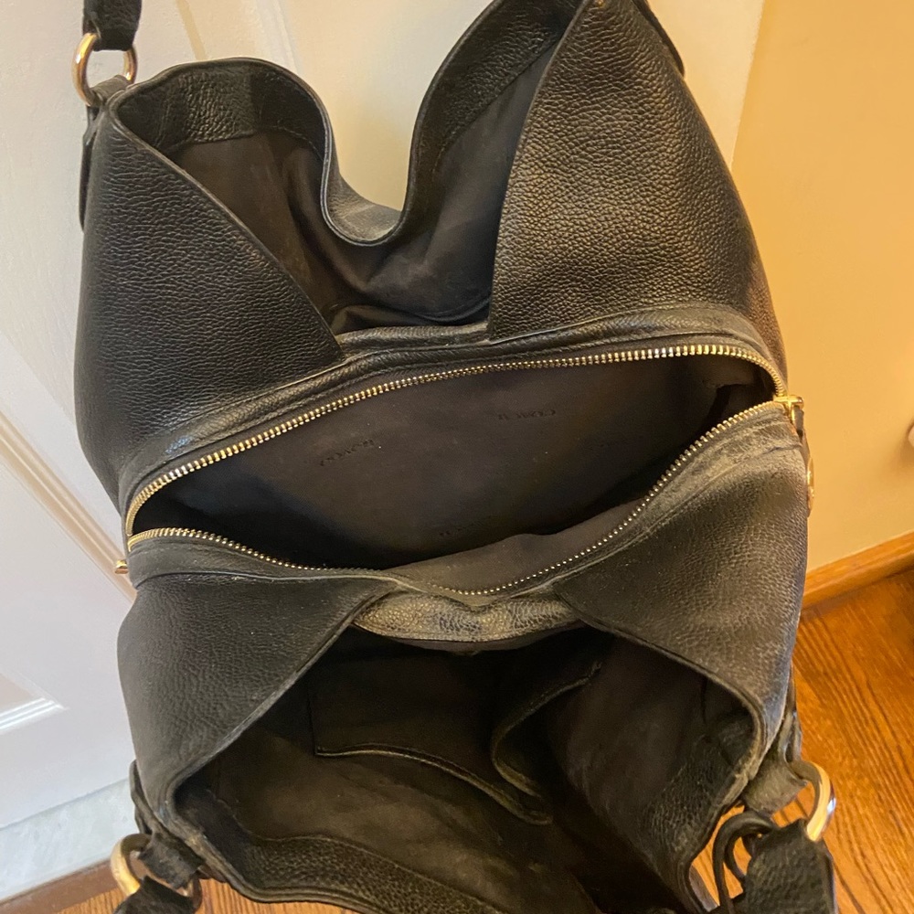 Black coach bag with three compartments and zippered middle
